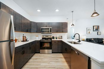 a large kitchen with wooden cabinets and stainless steel appliances